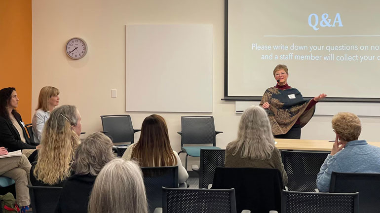 Councilmember Sarah Perry speaking to a group of seated constituents.