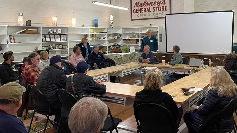 A group seated around a table at a town hall event.