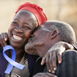 Wife and husband with blue ribbon representing early detection with colon cancer screening