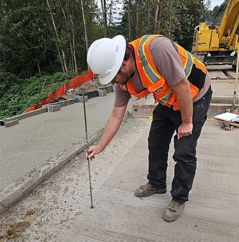 Geoscience consultant testing concrete.