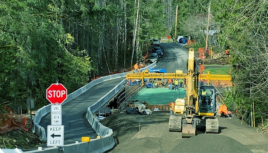 Crews use two large cranes to hoist the second of five massive girders for the new bridge.