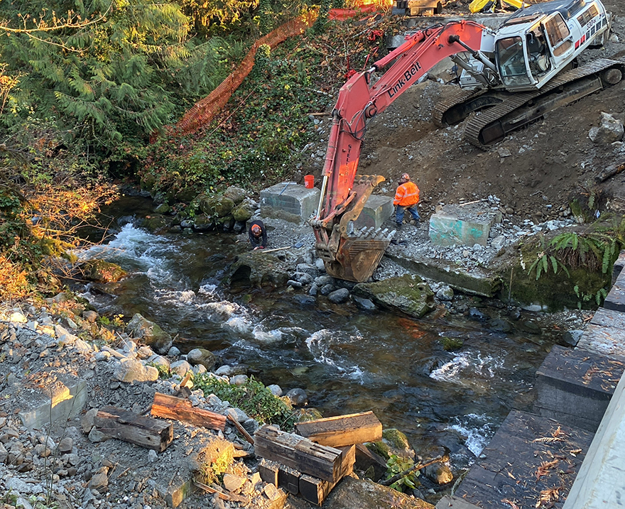  Nov. 14, 2022 – Contract crew members work to remove the footings of the old bridge with the help of an excavator.