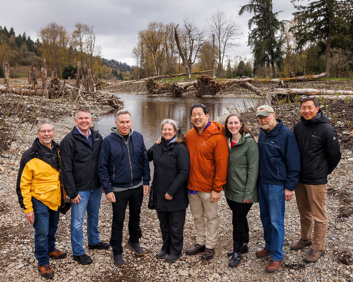 Partners stand together for a group photo along new side channel of Cedar River